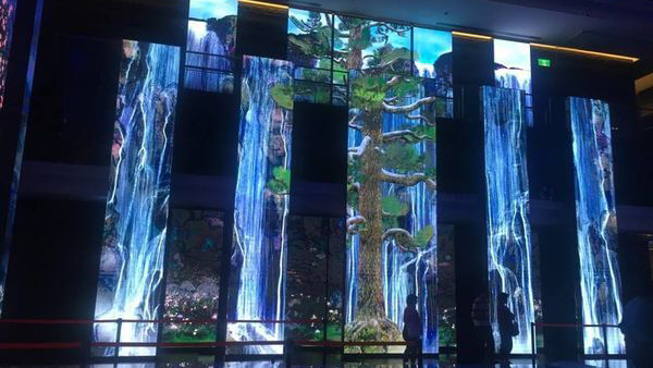 a video wall displaying a realistic and stunning video of a waterfall inside a business building, creating a positive impression for visitors with the help of LV-Tron technology